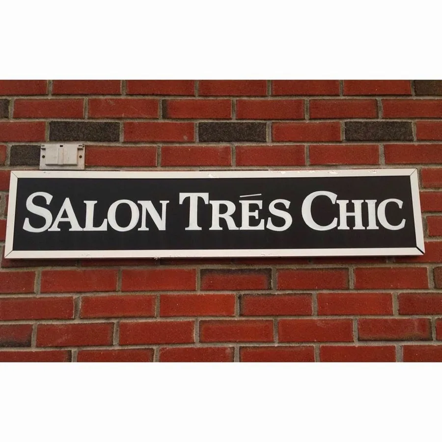 Salon Tres Chic sign on the exterior brick facade